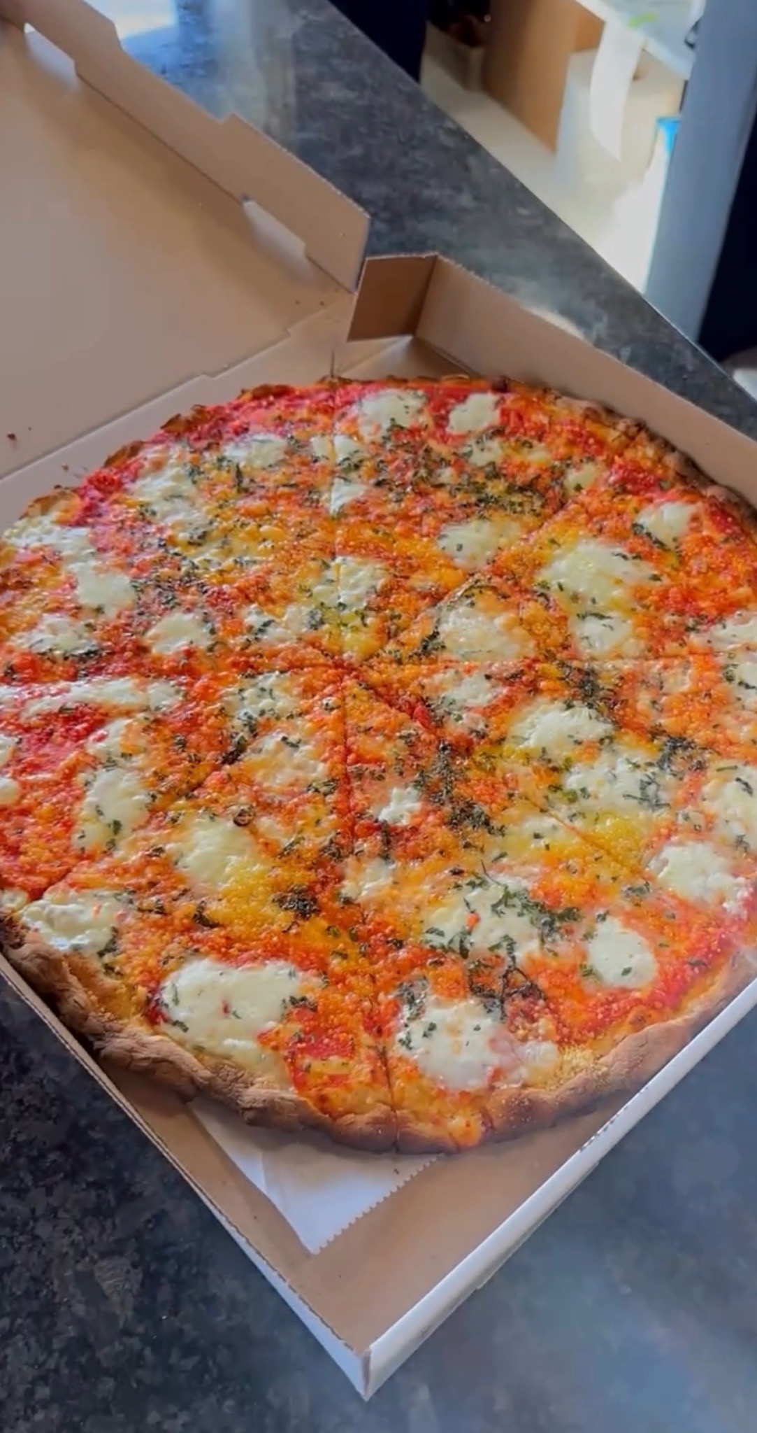 Burrata pie with tomato sauce, herbs, and fresh mozzarella